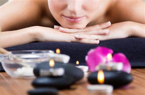 Ambiance de relaxation avec serviette, fleurs et pierres chaudes – illustration Lys Sensation